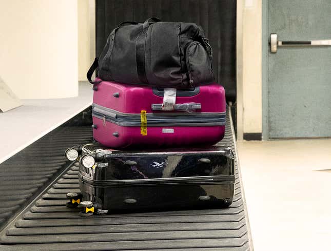 Image for article titled Duffel Bag Sitting Atop Two Suitcases On Luggage Carousel Like King On Opulent Throne